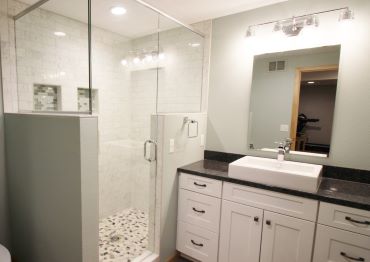 DETAILED BASEMENT REMODEL FEATURING A CUSTOM BATHROOM, RAILING, AND BUILT-INS